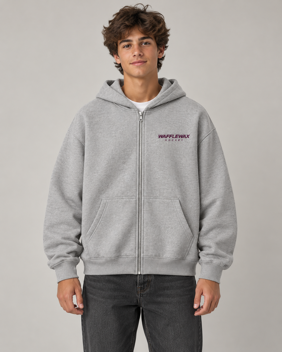 AI-generated front-view mockup of a teen model wearing the athletic grey EDGEWORK full-zip hoodie with a small plum WaffleWax Hockey chest logo.