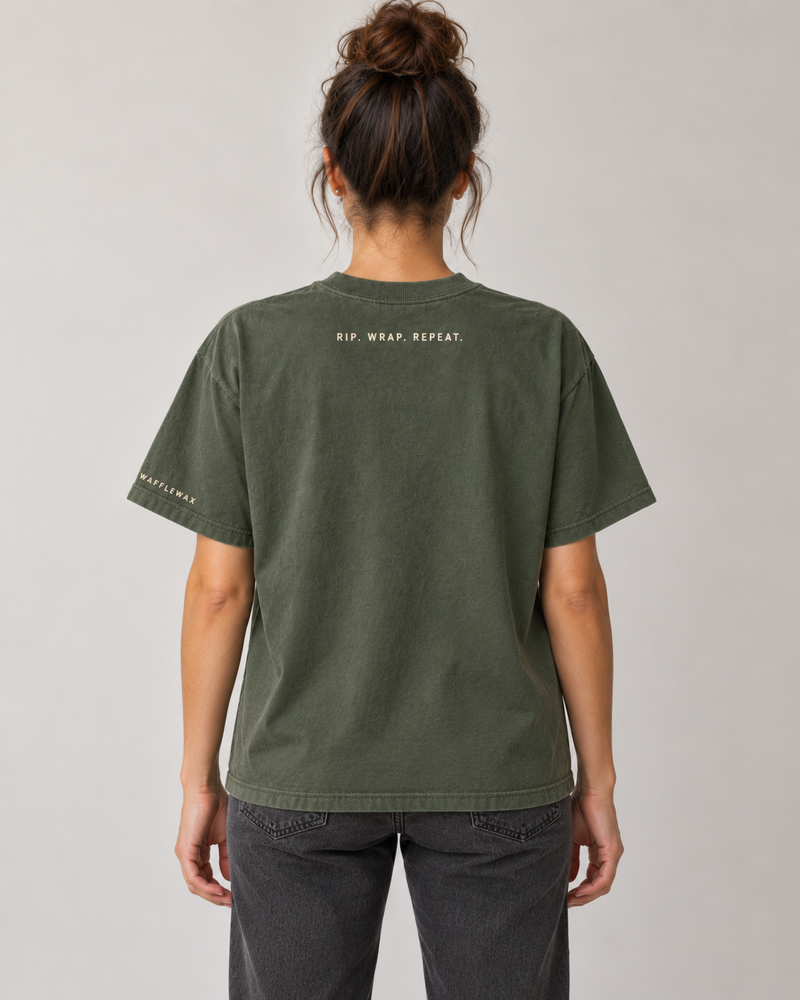 AI-generated mockup of the Tape Club tee back with RIP. WRAP. REPEAT. lettering and left-sleeve WaffleWax branding.